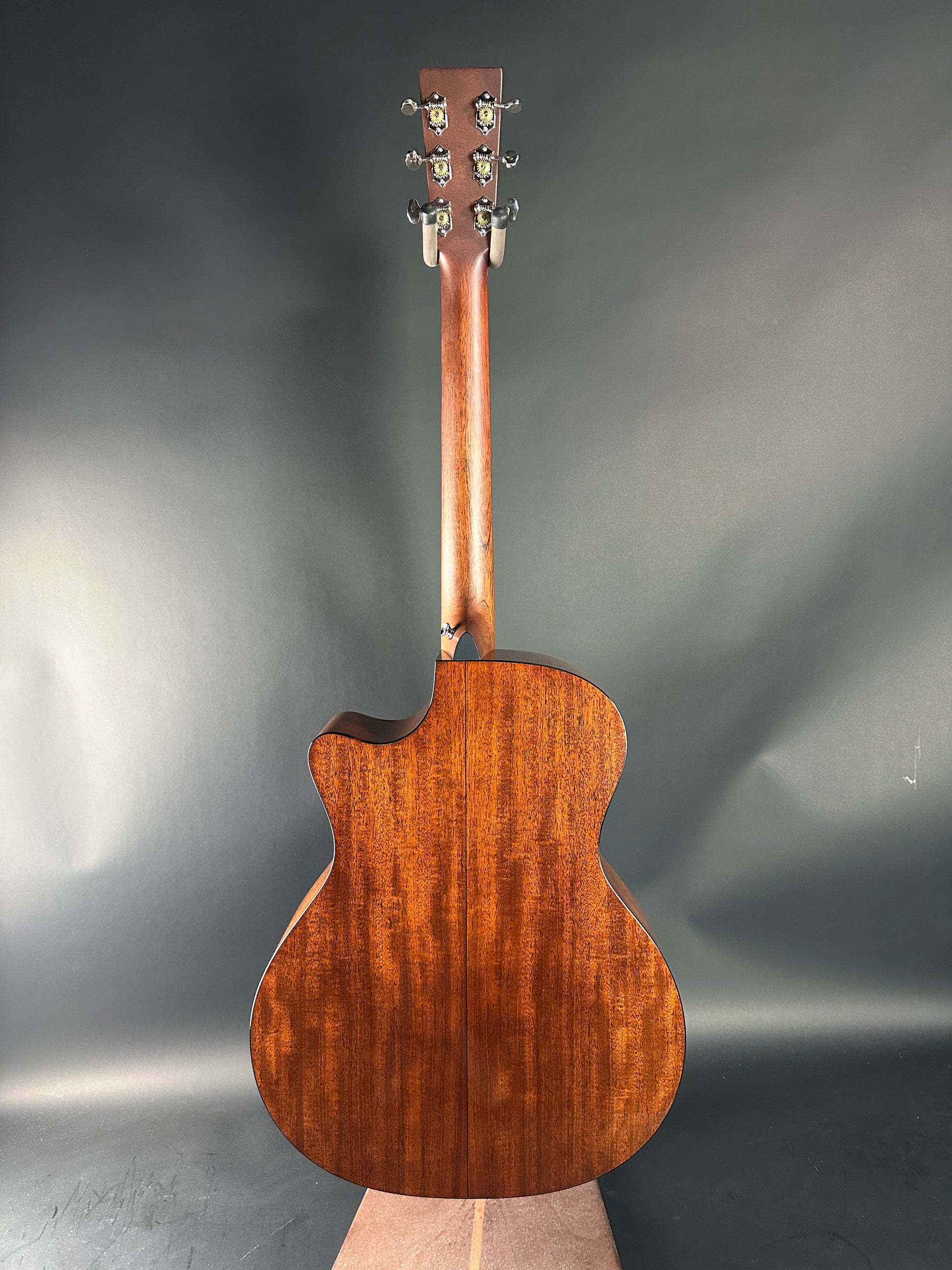 Wooden acoustic guitar body on a reflective gray surface