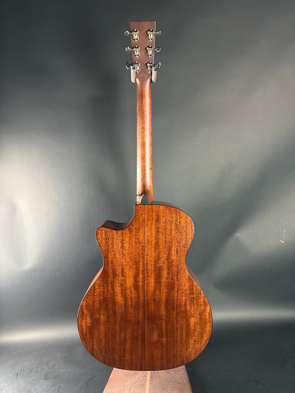 Wooden acoustic guitar body on a reflective gray surface