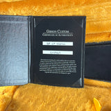 Gibson Custom Certificate of Authenticity on a yellow textured surface