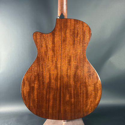 Back view of a wooden acoustic guitar on a gray background