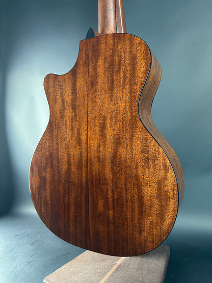 Close-up of a wooden guitar body against a gray background