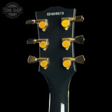 Guitar headstock with tuning pegs on a black background, featuring the Tone Shop logo.