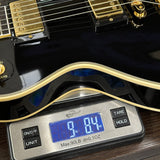 Digital scale displaying weight of a black electric guitar