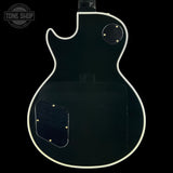 Back view of a black electric guitar with a visible brand logo in the corner.