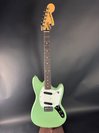 Green electric guitar on a dark gray background