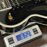 Guitar on a digital scale displaying weight