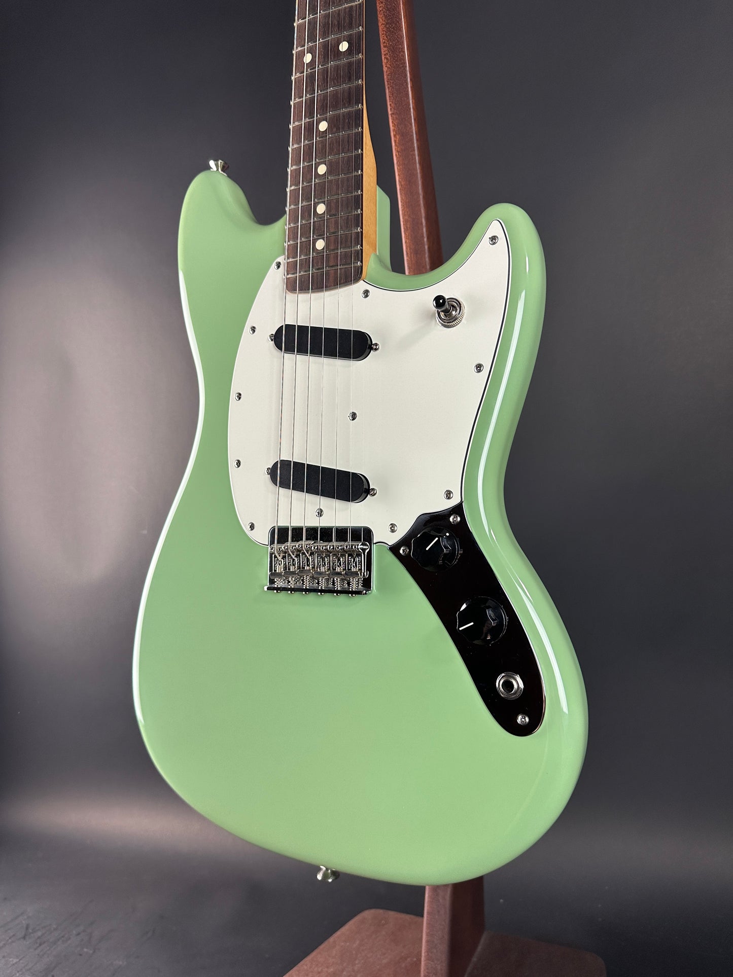 Green electric guitar on a dark gray background