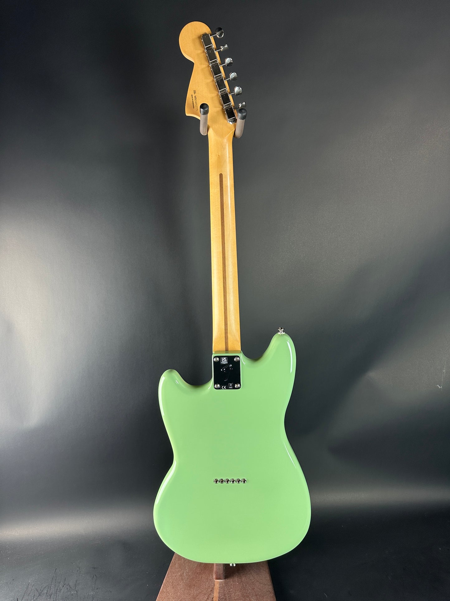 Green electric guitar on a dark gray background