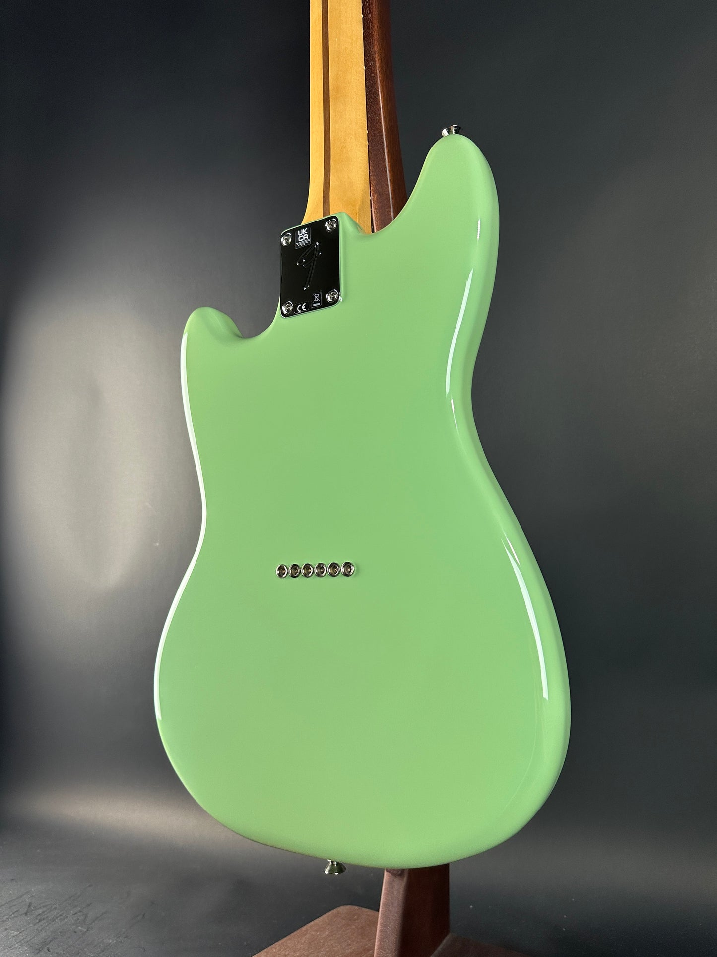 Green electric guitar body on a dark background
