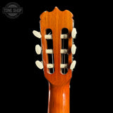Close-up of a guitar headstock with tuning pegs on a black background, featuring the Tone Shop logo.