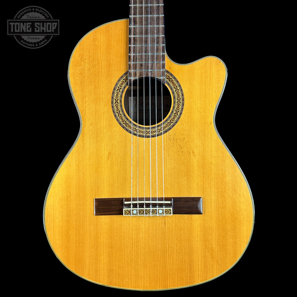Acoustic guitar with a visible brand logo on a black background