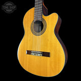Acoustic guitar with a visible brand logo on a black background