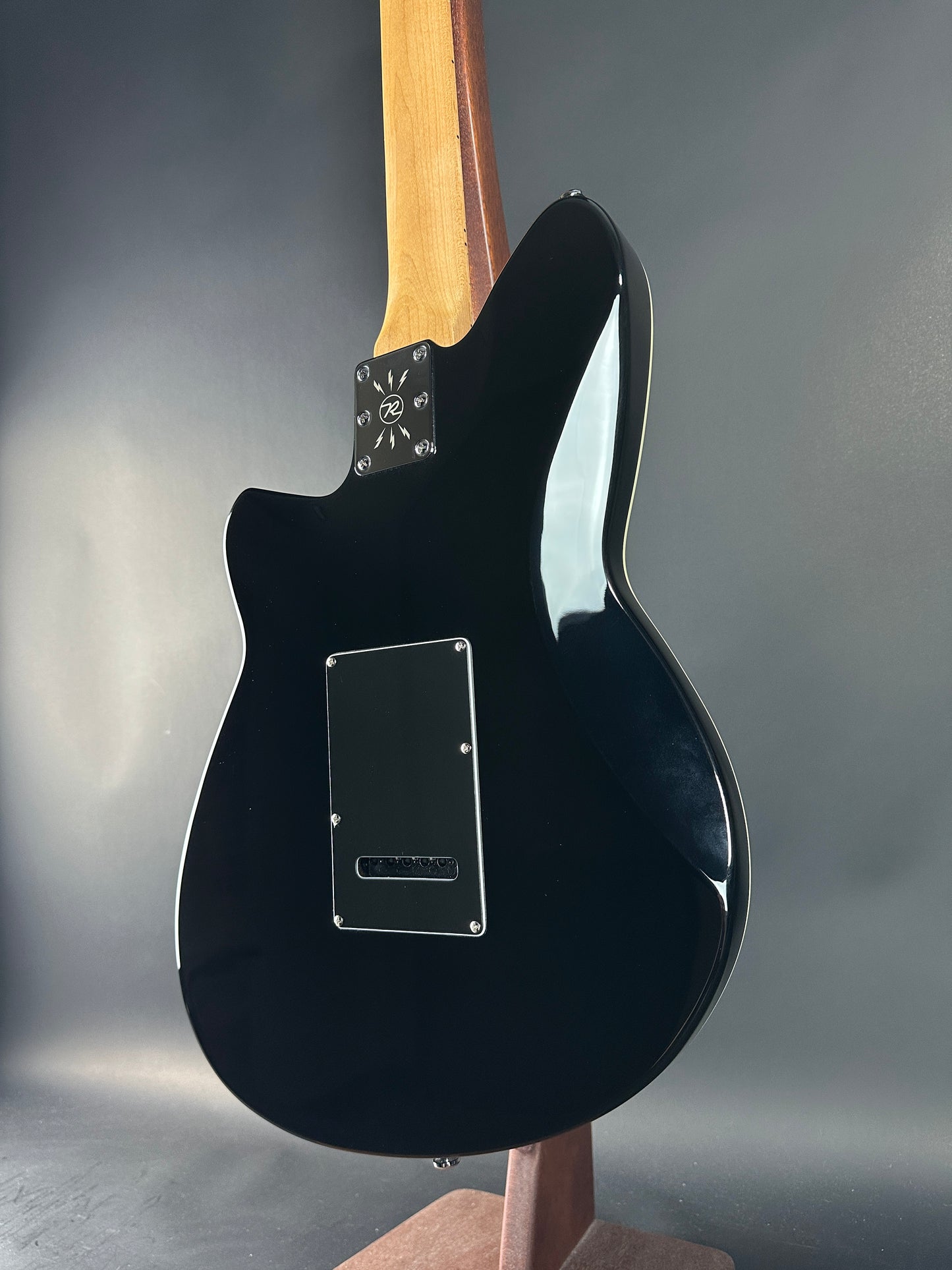 Black electric guitar on a gray background