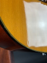 Close-up of a guitar's soundhole with a white pickguard.