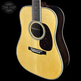 Acoustic guitar with a visible brand logo on a black background