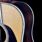 Close-up of an acoustic guitar's soundhole and wooden finish on a black background