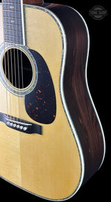 Acoustic guitar with a visible brand logo on a black background