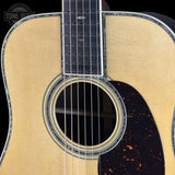 Close-up of an acoustic guitar with a visible brand logo in the corner.