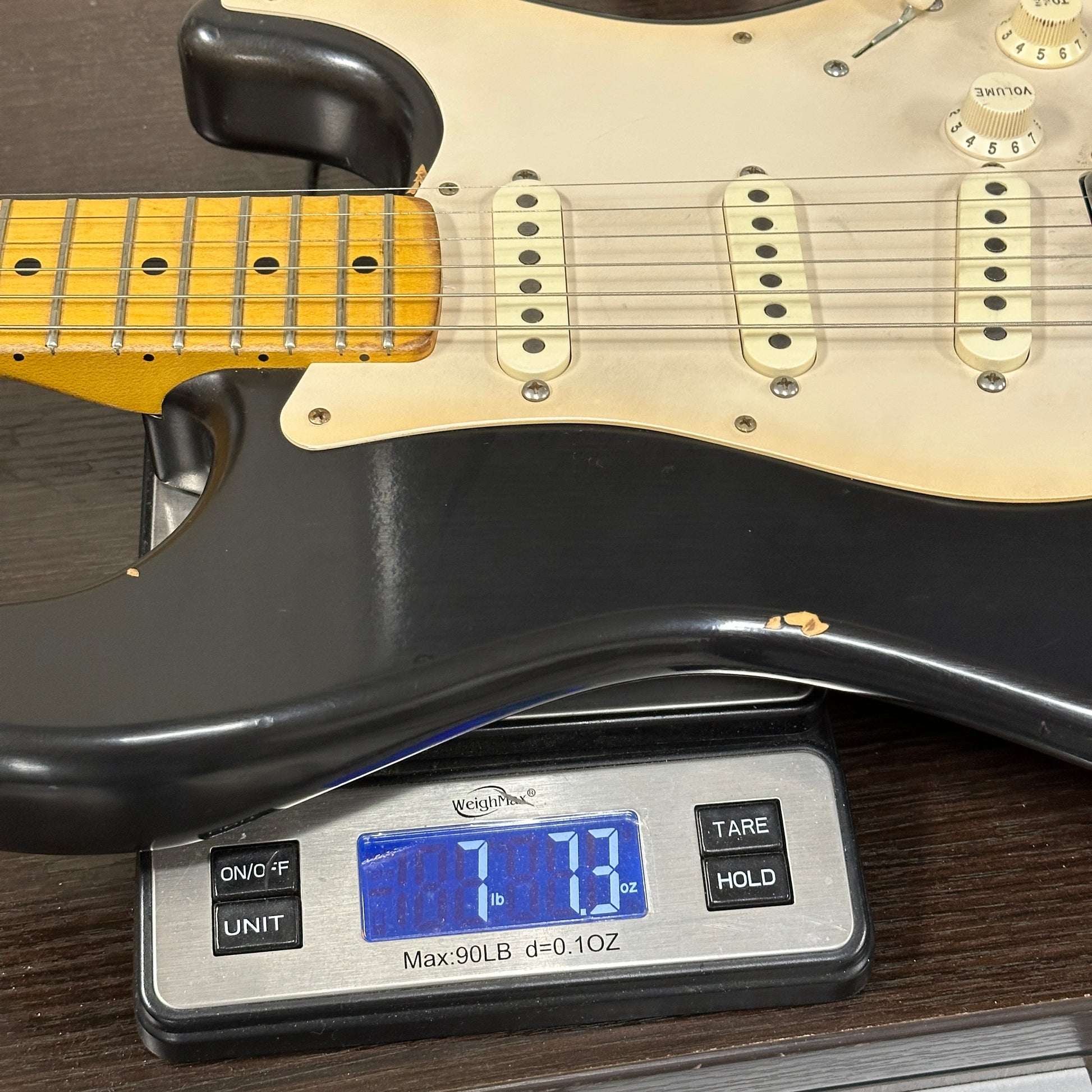 Guitar on a digital scale displaying weight