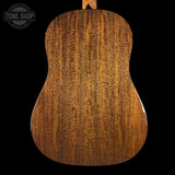 Back view of a wooden acoustic guitar with 'Tone Shop' logo.