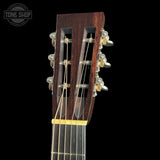 Close-up of a guitar's headstock with tuning pegs on a black background, featuring 'Tone Shop' branding.