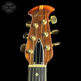 Close-up of a guitar headstock with brand logo on a black background