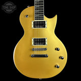 A gold-finish electric guitar with black pickups, chrome hardware, and a black neck, shown against a solid black background with a Tone Shop watermark in the top left corner.