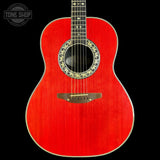 Red acoustic guitar with decorative soundhole on a black background, featuring 'Tone Shop' logo.