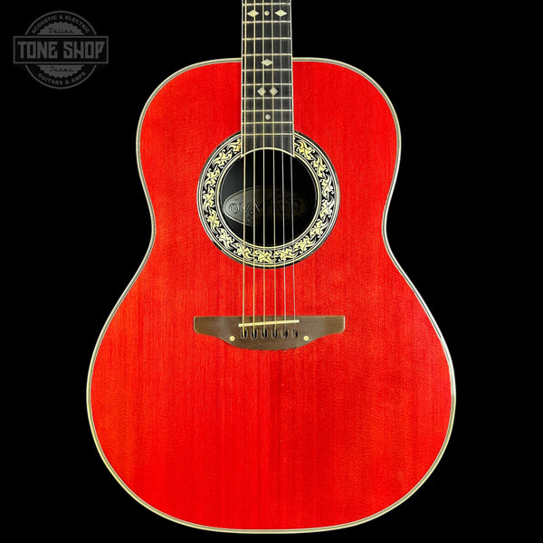 Red acoustic guitar with decorative soundhole on a black background, featuring 'Tone Shop' logo.