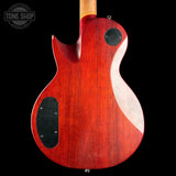 The back of a red electric guitar with a glossy cherry red finish, black pickups, and a light wood neck, shown against a black background with a Tone Shop watermark in the top left.