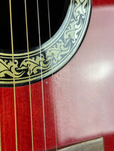 Close-up of a guitar's soundhole and strings with decorative inlay.