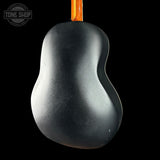 Black acoustic guitar body with a visible brand logo on a black background