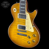 Electric guitar with a sunburst finish on a black background, featuring the Tone Shop logo.