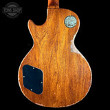 Wooden guitar body with a visible brand logo on a black background