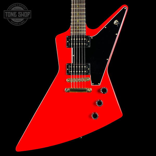 Red electric guitar with a unique design on a black background, featuring the 'Tone Shop' logo.