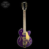 A purple electric guitar with gold hardware and a gold pickguard, shown vertically against a solid black background. A Tone Shop watermark is visible in the top-left corner.