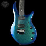 Blue electric guitar with a glittery finish on a black background, featuring the Tone Shop logo.