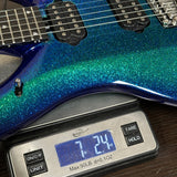Blue glittery electric guitar on a digital scale displaying weight.