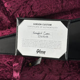 A Gibson Custom Certificate of Authenticity card displayed inside a black presentation box on a deep magenta velvet surface. The card is labeled for the 'Hummingbird Custom' serial 2/16/1503, with the Gibson logo visible at the bottom.