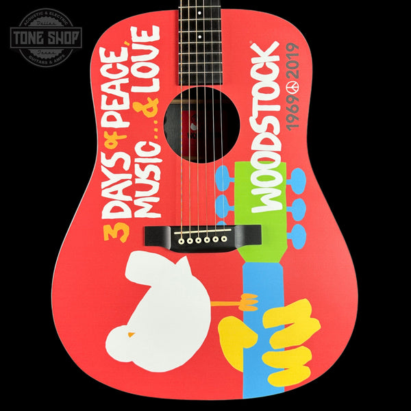 Woodstock-themed guitar with colorful design and text on a red background