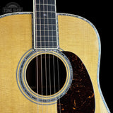 Close-up of an acoustic guitar body showing the natural wood grain top, sound hole, rosette, and part of the dark fretboard against a black background. A Tone Shop watermark is visible in the top left corner.