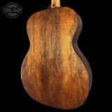 Close-up of a wooden acoustic guitar body with 'Tone Shop' logo.