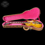 A gold-top electric guitar resting inside an open vintage-style hard case with a bright pink velvet interior, photographed against a solid black background. A Tone Shop watermark is visible in the top-left corner.