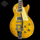 A Les Paul style electric guitar with a natural flamed maple top, cream pickguard, and a black tailpiece, shown against a solid black background with a Tone Shop watermark in the top left corner.