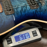 Guitar being weighed on a digital scale with a blue finish