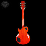 A red electric guitar shown from the back against a solid black background, featuring a glossy cherry red finish, a black pickguard, and a black tailpiece cover. A Tone Shop watermark is visible in the top-left corner.