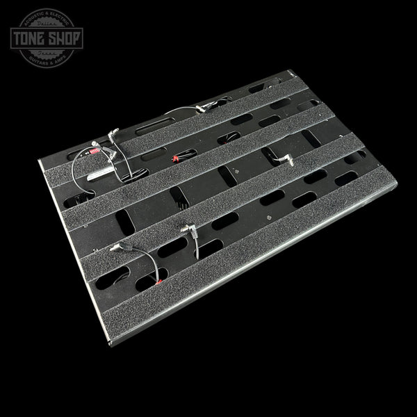 Metal guitar effects pedal board with visible wiring on a black background, featuring the Tone Shop logo.
