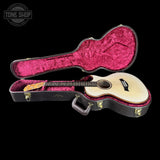 Acoustic guitar in a black case with red interior on a black background, featuring 'Tone Shop' logo.
