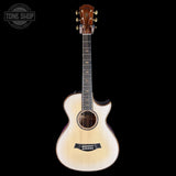 Acoustic guitar with a visible brand logo on a black background