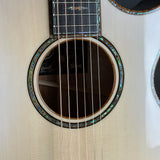 Close-up of an acoustic guitar's soundhole and brand logo.